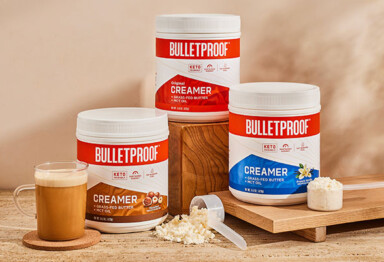 the family of three bulletproof creamers, original hazelnut and vanilla, sit next to each other next to a cup of coffee and individual scoops of creamer