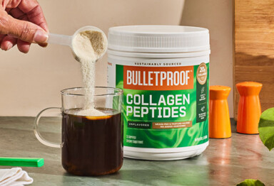 Hand pouring a scoop of Bulletproof Unflavored Collagen Peptides into a cup of coffee